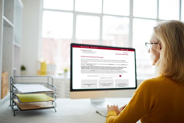 Symolbild einer Frau, die auf ihrem Computer die Seite des Infoservice aufruft